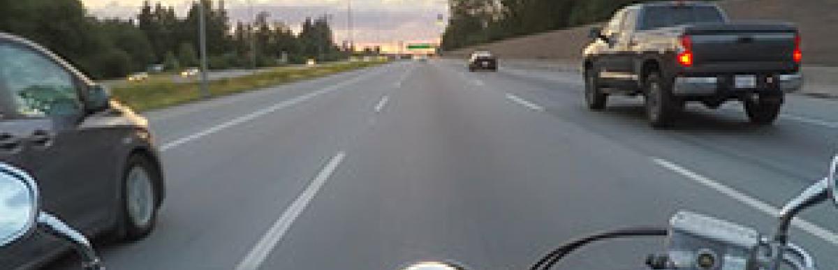 Motorcyle driving on road with cars
