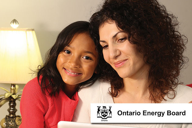 Mother and daughter sitting on a couch at home using a computer