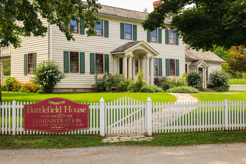 beige siding house with white picket fence