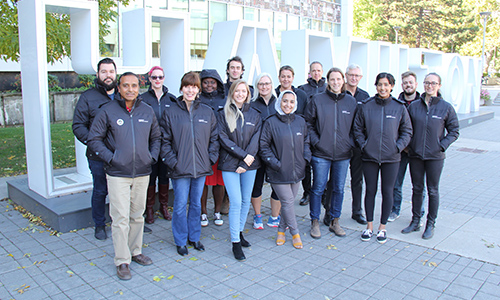 Group of Community Connectors posing in front of Hamilton Sign at City Hall