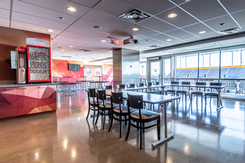 Lounge with tables and chairs with view of stadium field