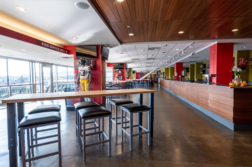 Lounge with tables and chairs with view of stadium field