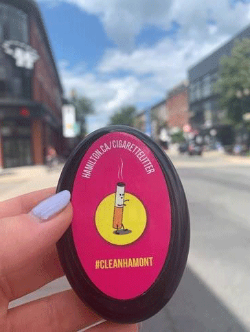 Woman's hand holding a pocket ashtray