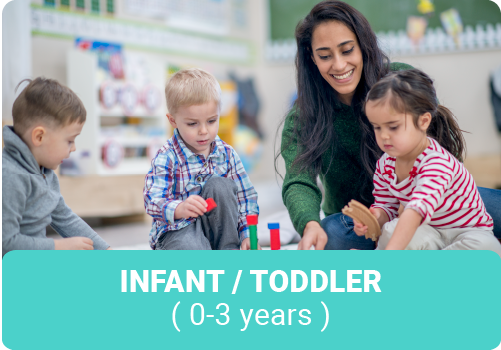 Young woman child caregiver playing blocks with three toddlers