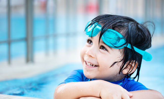 Smiling young boy wearing swim goggles