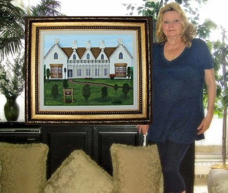 Woman standing next to framed painting
