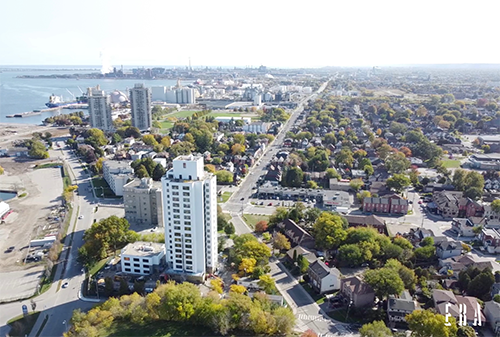Overhead view of apartment building surrounded by houses and trees