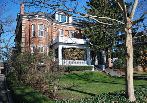 Two storey victorian home with bay windows and front porch.