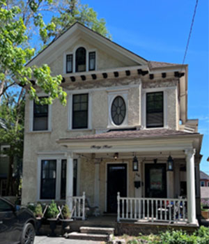 Three storey cream house with covered front proch