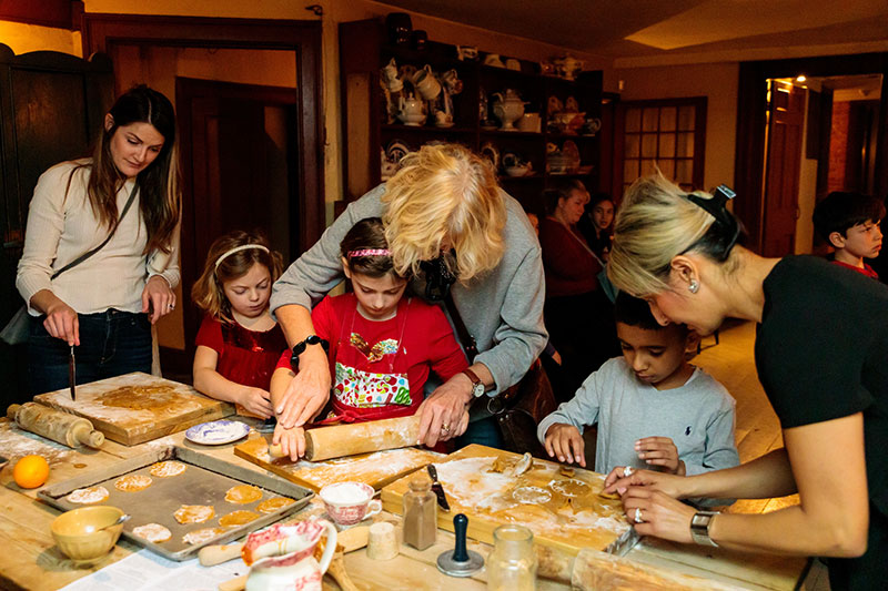 Families with children rolling out dough in the Dundurn Castle kitchen