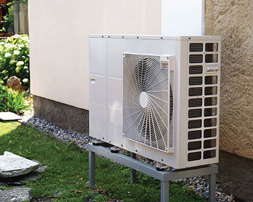 High efficiency air conditioning unit installed outside beside house.