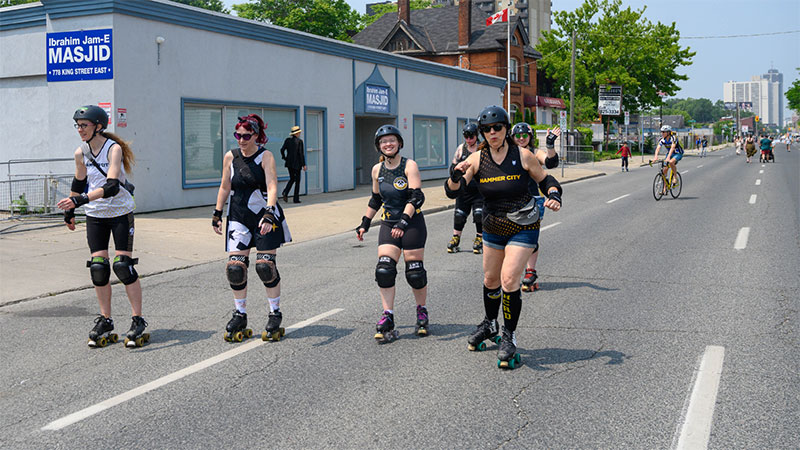 Members of the Hammer City Roller Derby League skate down King Street during Open Streets 2023