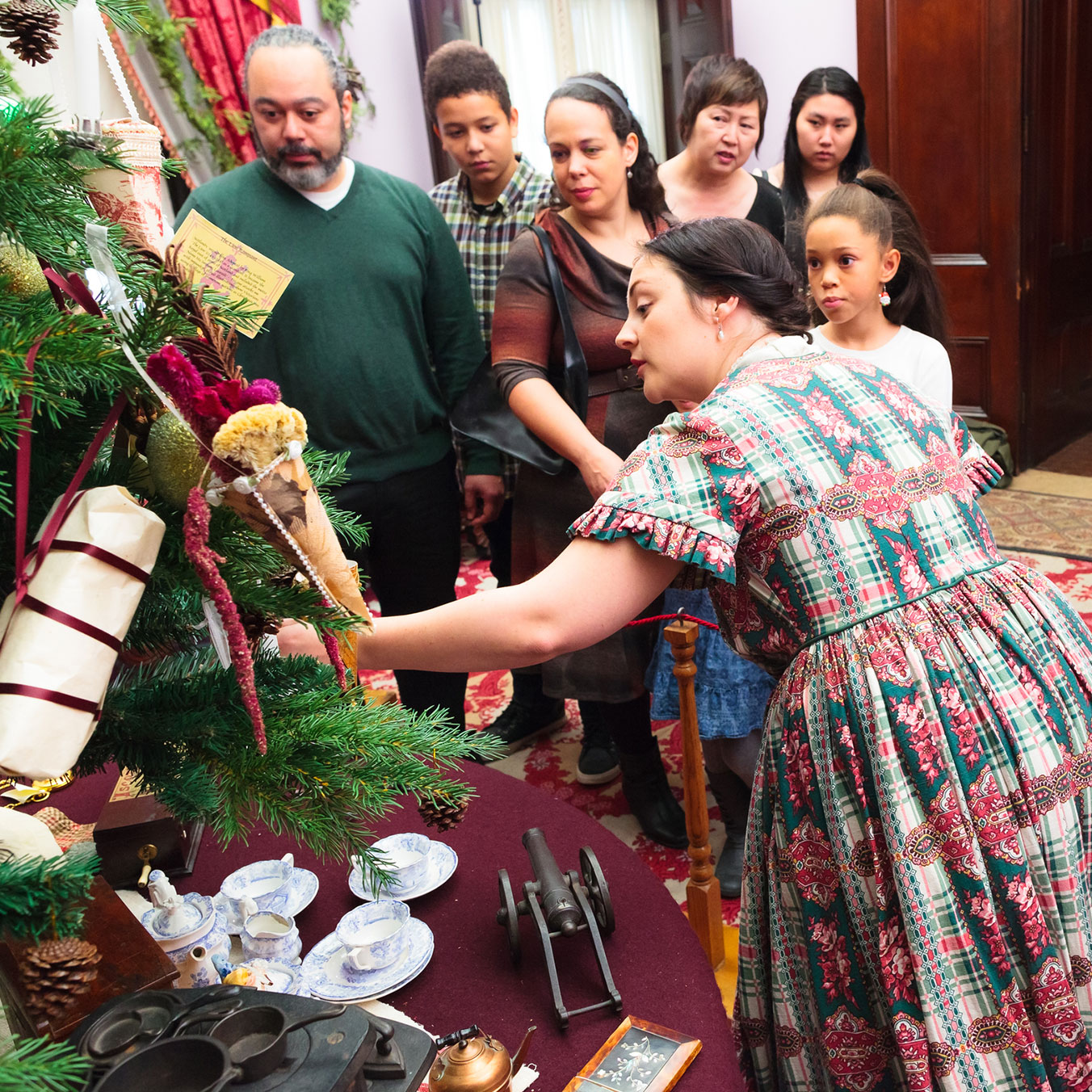Staff member showing christmas decor at Dundurn to group of visitors