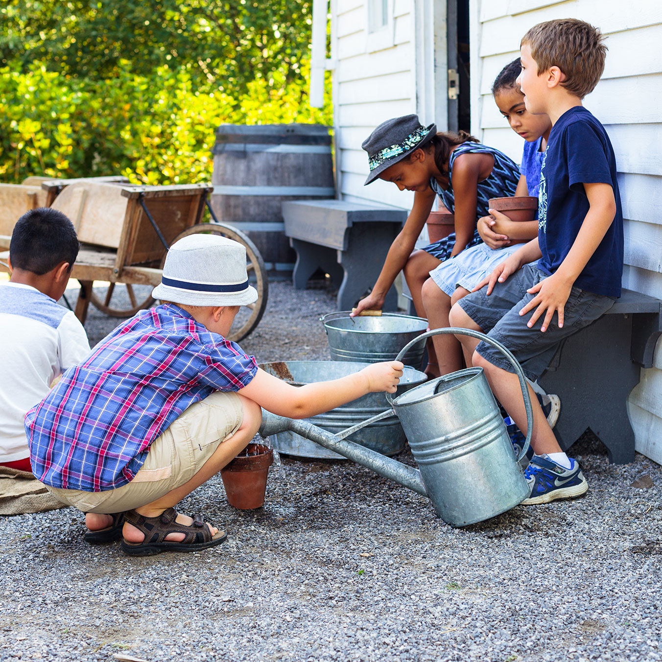 A small group of children playing with watering cans and buckets in Kitchen Garden at Dundurn