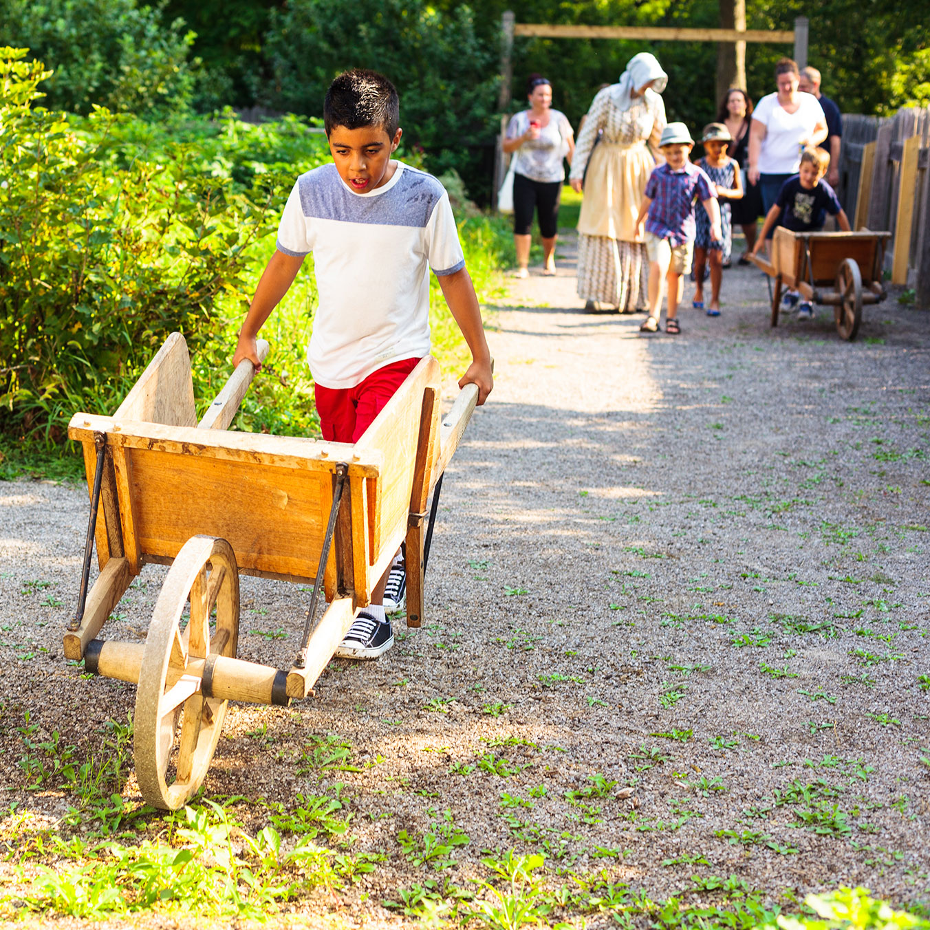 Kids pushing wheelbarrows in kitchen garden at Dundurn National Historic Site