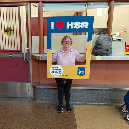 HSR’s Track Your Trip Study winner Kathleen posing with I Love HSR sign