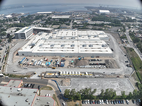 Photo taken on July 16, 2025 looking north towards Lake Ontario. The compressed natural gas station is at the bottom of the photo and the 4-level parking structure and elevated administration building are located at the top left. Driveway curbing has commenced, and landscaping will start in early Fall.