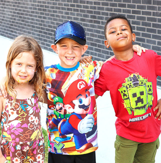 Three kids smiling at camera 