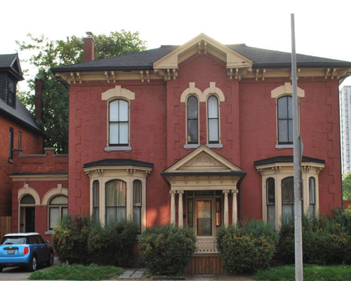 2 storey italianate home with original windows, front door and covered porch
