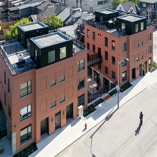 Pair of modestly-scaled 4 storey apartment building linked by functional bridge in Beasely neighbourhood.