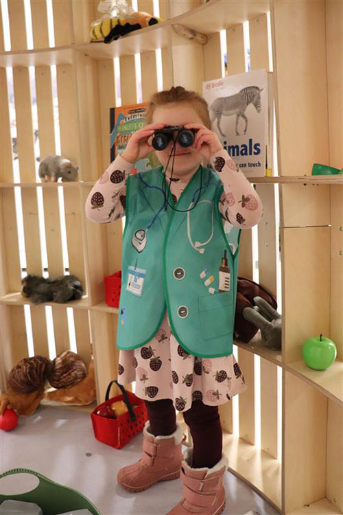Child dressed in a costume and using binoculars