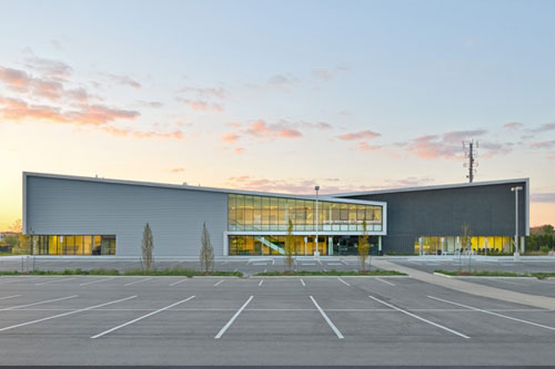 Exterior of Harry Howell Twin Pad Arena from the parking lot with the sun setting behind the building