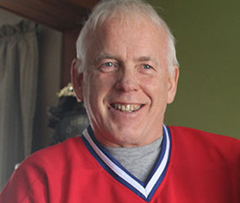 Shoulders up portrait of John Ross - man in a red jersey.