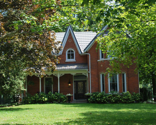 Two storey red brick home with covered porch