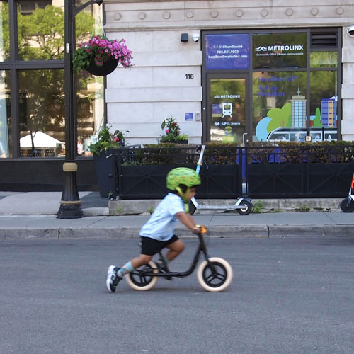 A child rides a small bike on King Street east during Open Streets