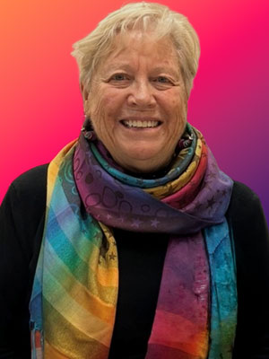 Smiling woman with a rainbow scarf and white hair 
