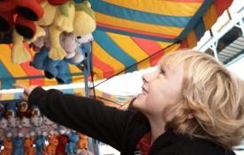 Young boy playing games at the midway at a fall fair/festival