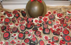 Helmet with poppies painted on rocks for Remembrance Day