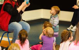 children sitting around an adult reading a story