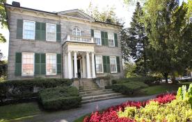 Exterior of Whitehern a 2 storey grey brick building with front porch and circular drive