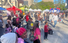 A crowd of smiling people of all ages gather outside of Hamilton City Hall for Newcomer Day