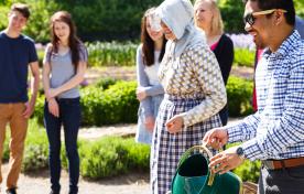 A group of people watering flowers in Historic Garden at Dundurn