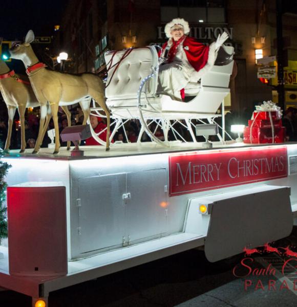 Mrs. Claus sitting in a sleigh pulled by reindeer - Santa Claus Parade float