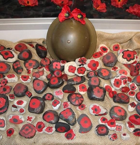 Helmet with poppies painted on rocks for Remembrance Day