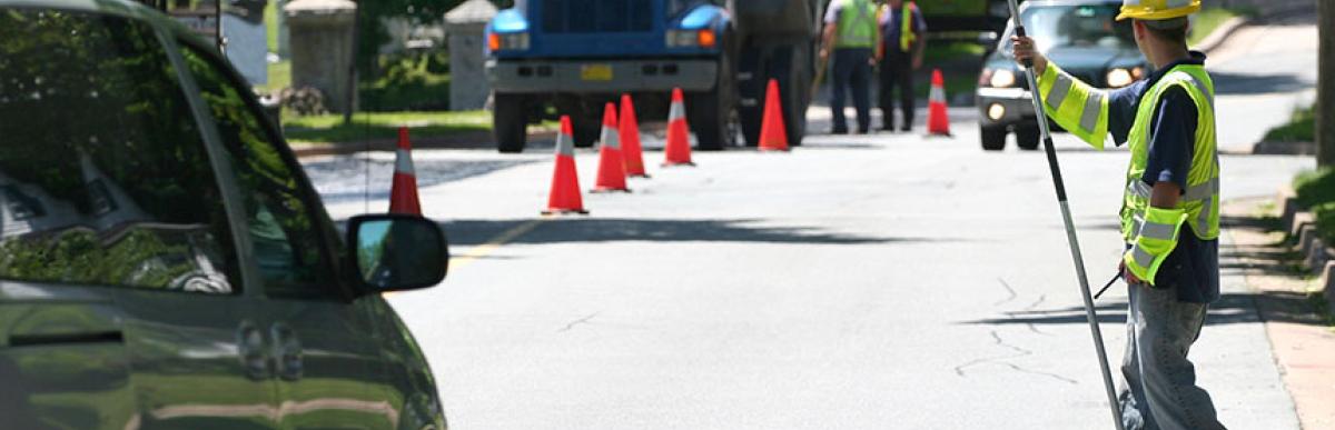 Construction worker stopping traffic for road construction