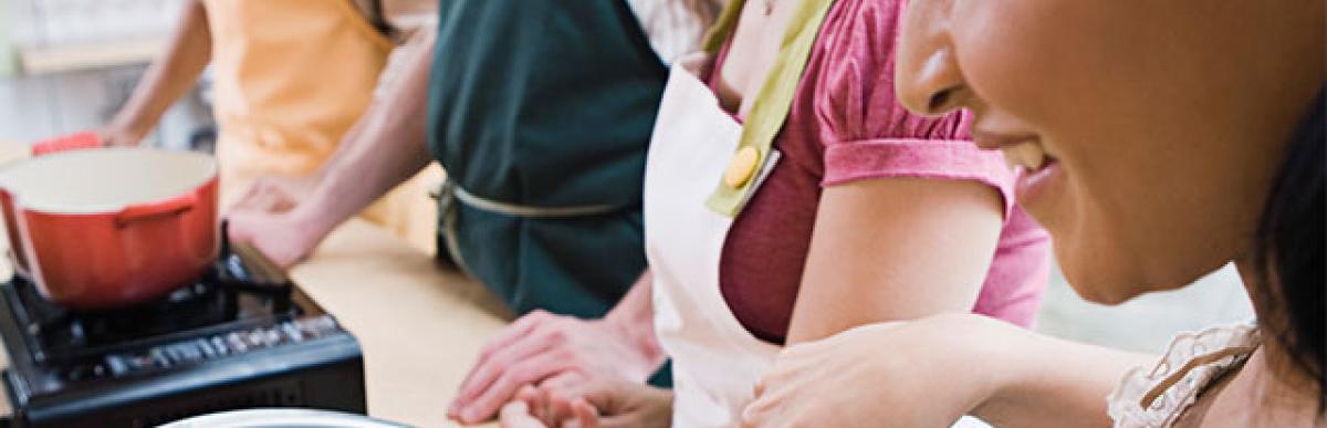 Group of mid-adults learning to cook and whisk eggs