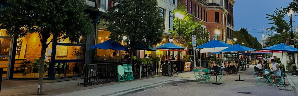 Diverse people sitting in an outdoor dinning area in the Downtown Core