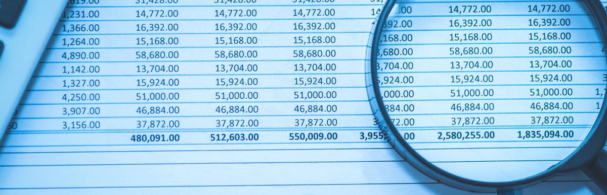 Financial table with magnifying glass and calculator