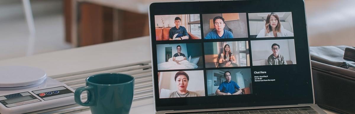 Laptop with screen video conference on kitchen counter with smart phone , note pad. Work from home concept.