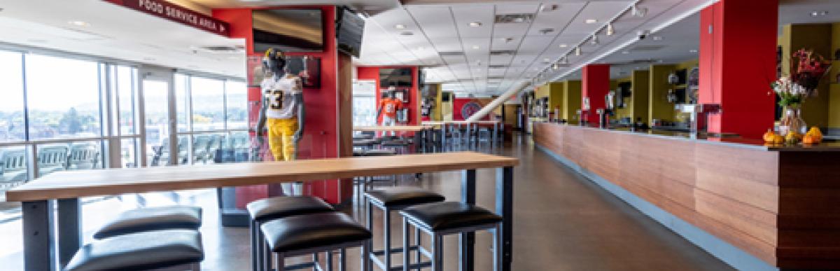 Lounge with tables and chairs with view of stadium field