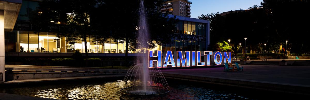 City Hall at night with the Hamilton Sign lit up and fountain