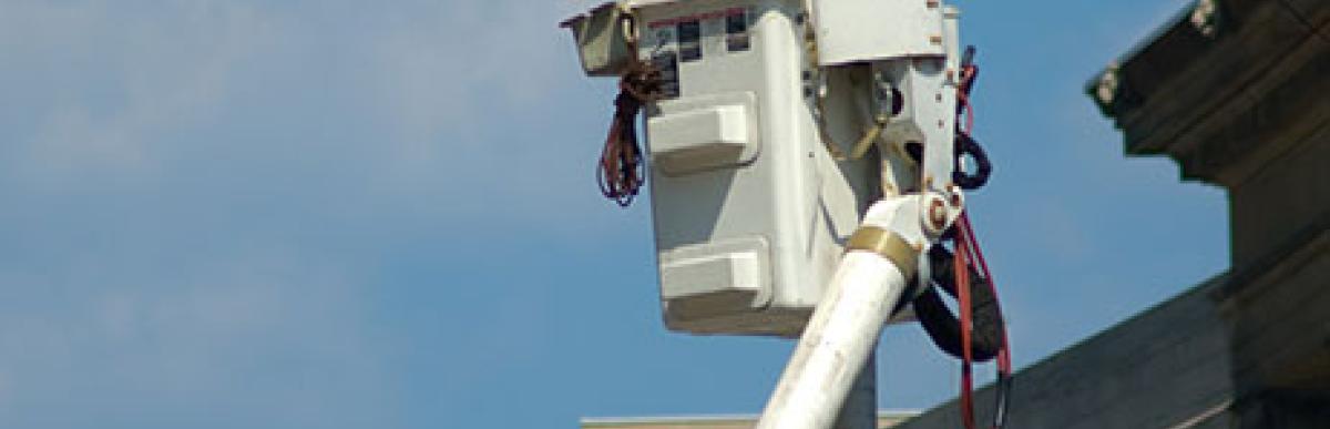 Worker in lift machine repairing street light