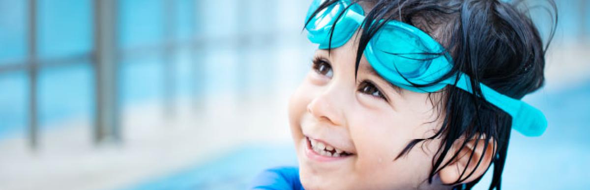 Smiling young boy wearing swim goggles
