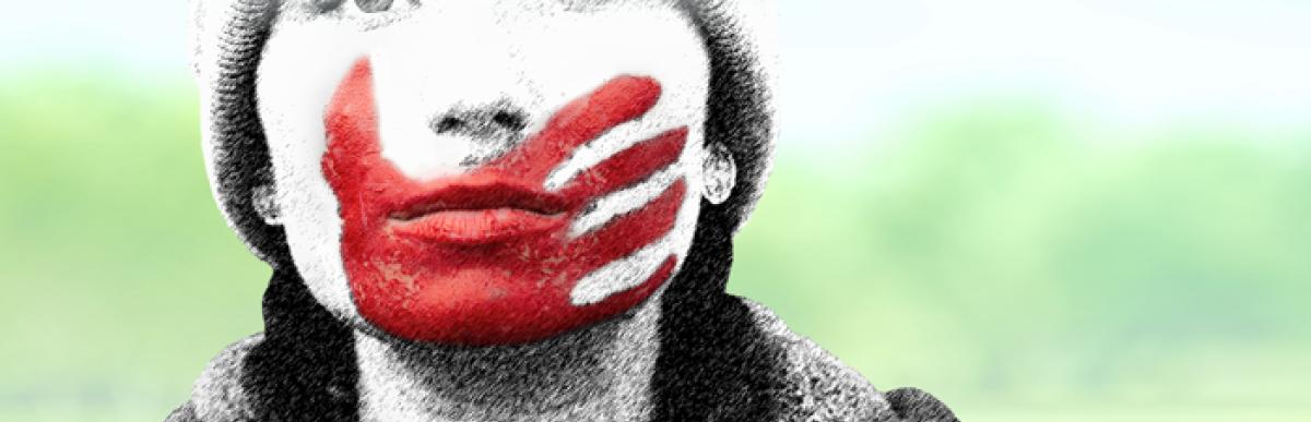 indigenous woman with red painted hand over her mouth