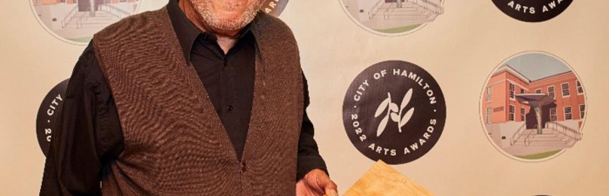 Image of man holding arts award medal
