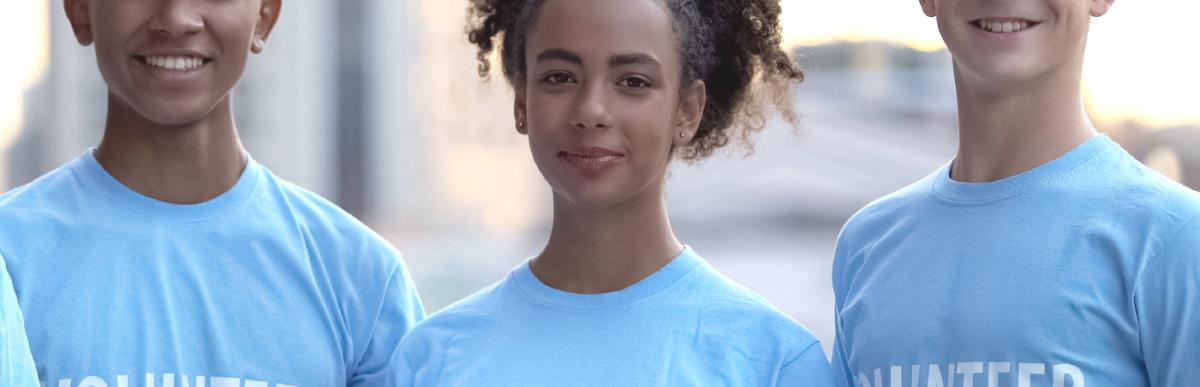 Three people in a row wearing shirts that say "Volunteer"